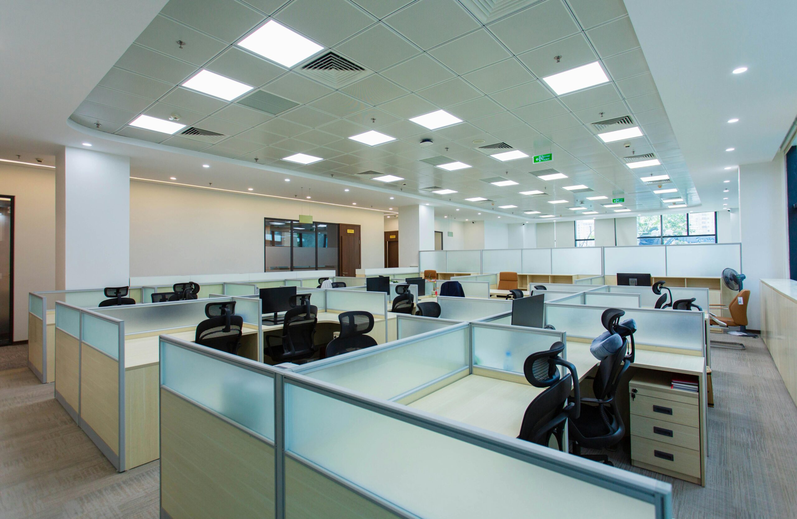 Spacious open-plan office with cubicles and modern furnishings, ideal for collaborative work environments.